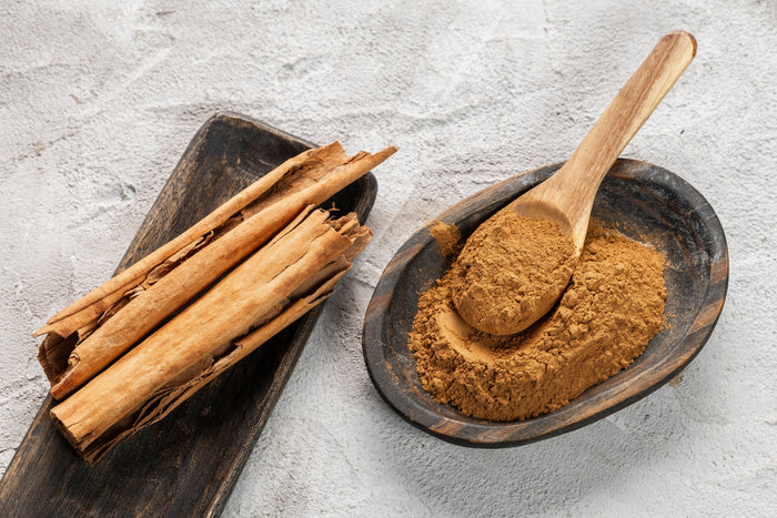 Ceylon cinnamon sticks and ground cinnamon powder in wooden bowl – comparing sticks vs powder for everyday use