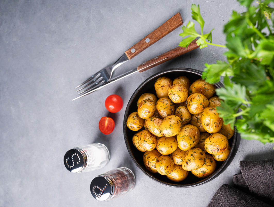 Roasted potatoes with fresh herbs on grey surface – black pepper garlic roasted potatoes recipe