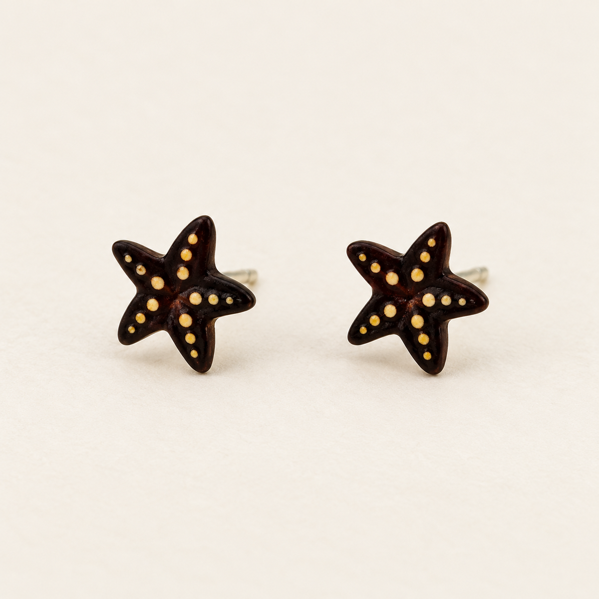 Brown Starfish Stud Earrings with Yellow Details, pair on an ivory studio background