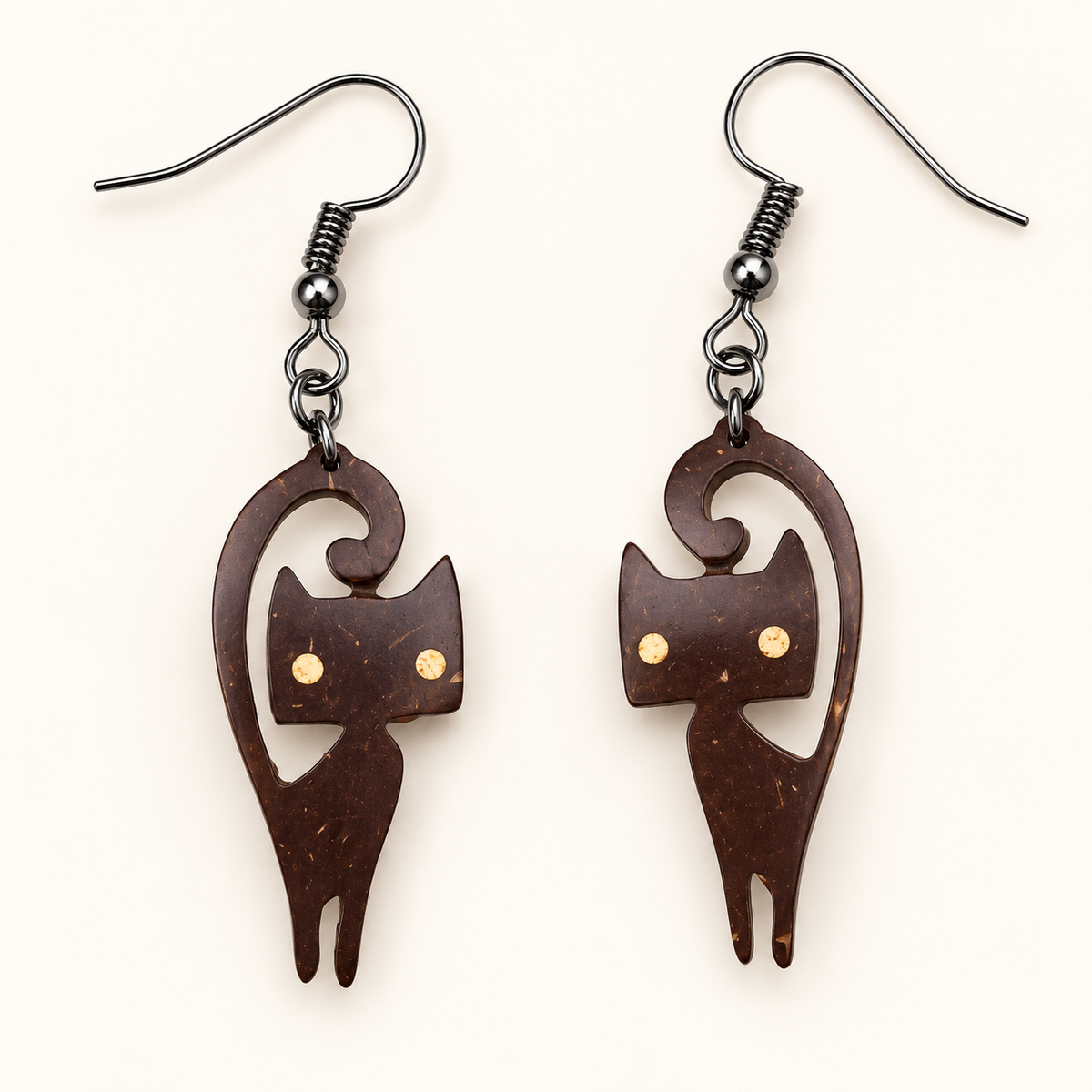 Curled-Tail Cat Coconut Shell Dangle Earrings, studio pair on an ivory background