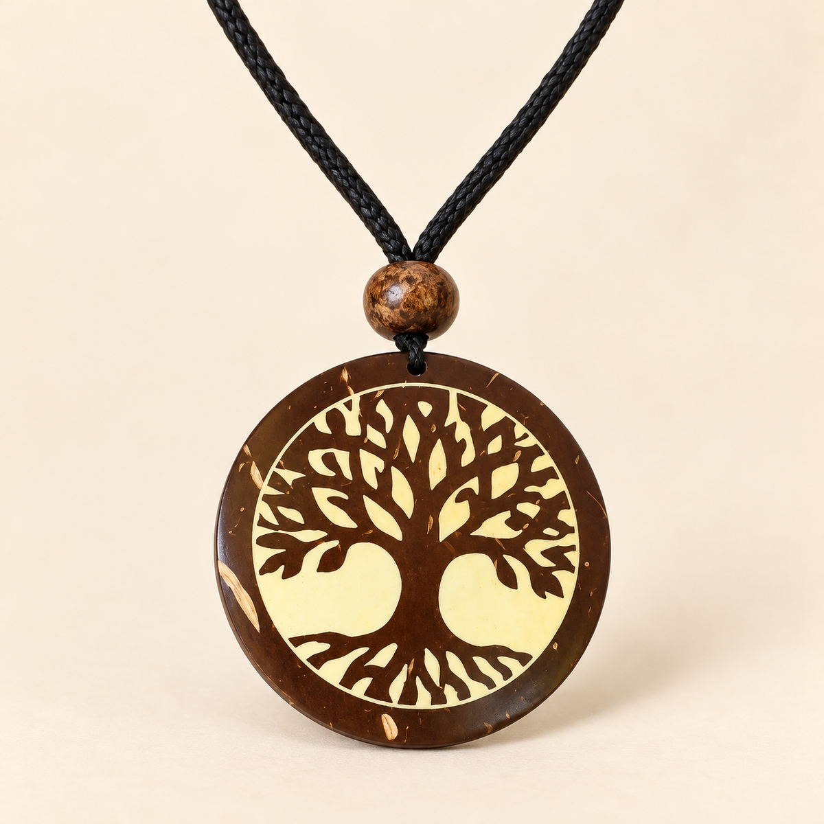 Golden Tree of Life Round Pendant Necklace, studio view showing pendant, bead and black cord on ivory background