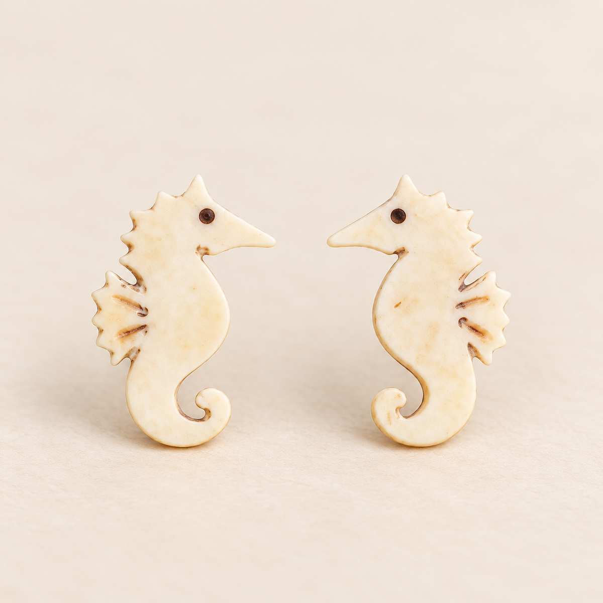 Ivory Seahorse Stud Earrings, pair on a clean ivory studio background