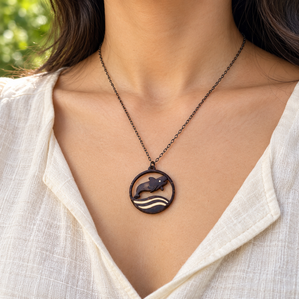 Pilot Whale and Waves Coconut Shell Pendant Necklace, worn by a woman