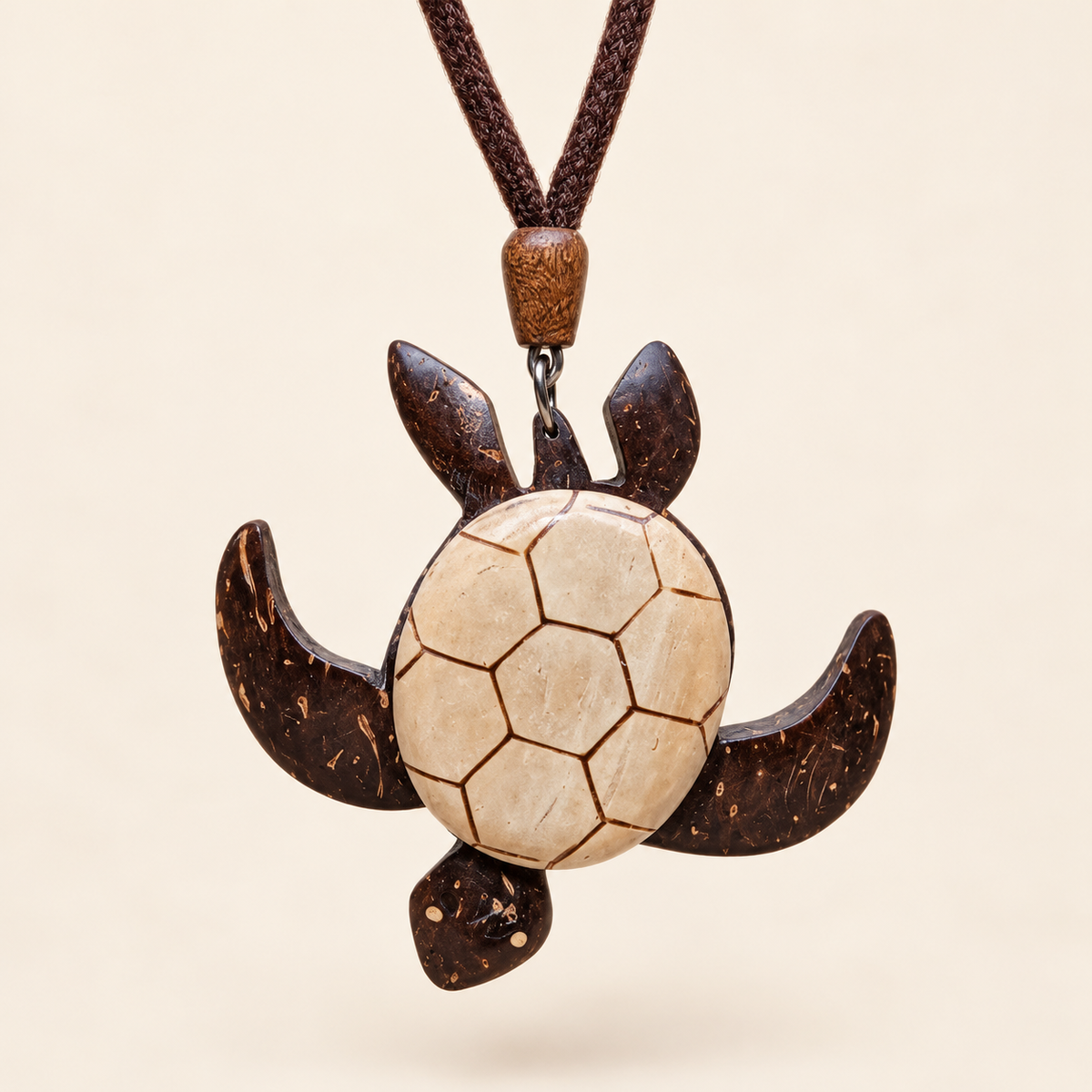 Swimming sea turtle coconut shell pendant necklace, front view on an ivory background